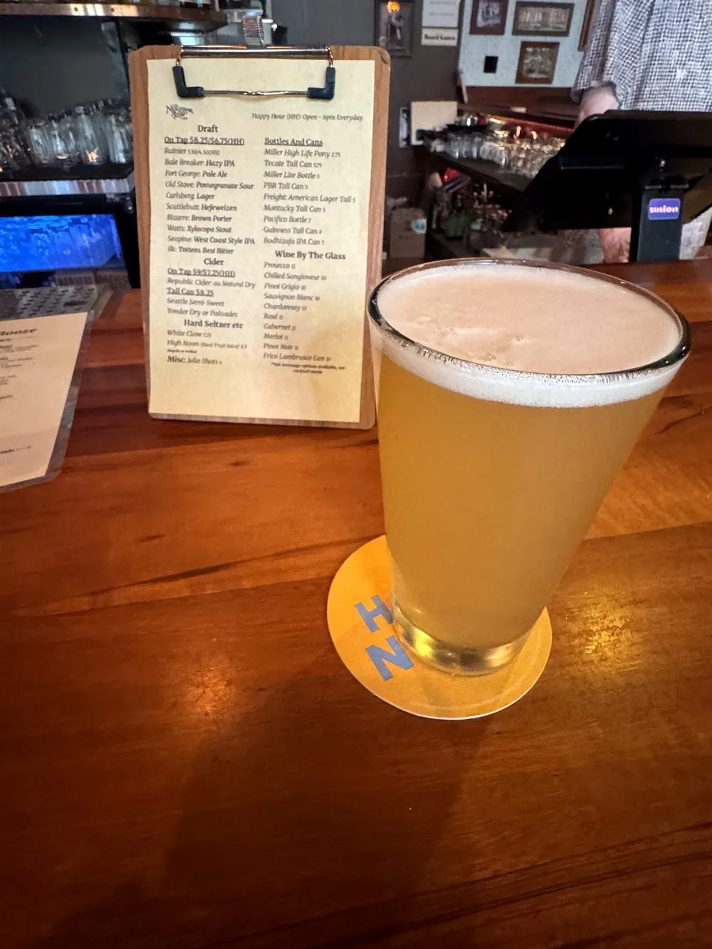 A pint on the worn wooden bar top at The Neighbor Lady
